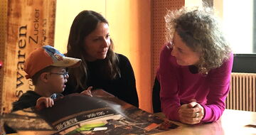 Chariklia Lehmann, Iris Kühnberger und ein kleiner Junge im Gespräch am Tisch Chariklia Lehmann, Iris Kühnberger und ein kleiner Junge im Gespräch am Tisch