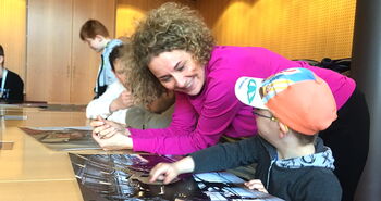 Am Besprechungstisch in der Runde: Kleiner Junge zeigt Iris Kühnberger sein Foto Am Besprechungstisch in der Runde: Kleiner Junge zeigt Iris Kühnberger sein Foto