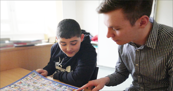 Shawn Röpke über seine Erfahrungen als erzieher in Ausbildung in einem Förderzentrum Erzieher in Ausbildung schaut mit einem Schüler ein Bilderbuch an