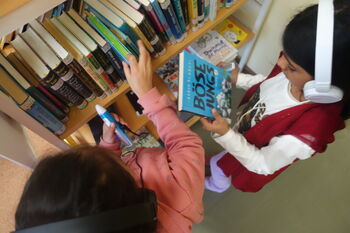 Kinder am Bücherregal mit Kopfhörer Kinder am Bücherregal mit Kopfhörer